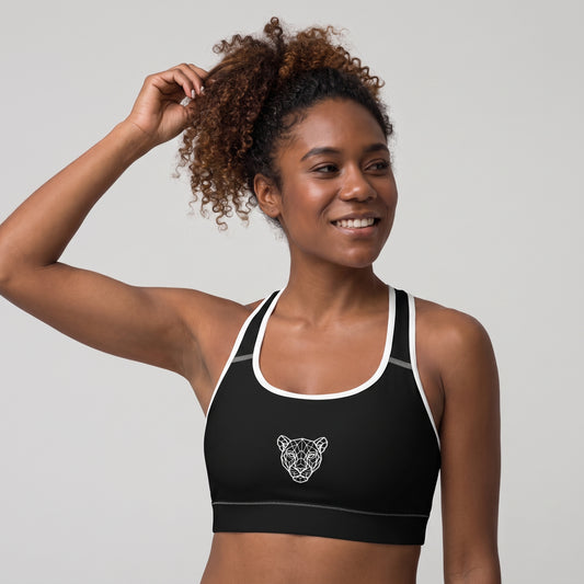 Angled front view of the KING Lioness Sports Bra in black with white piping on a female model.