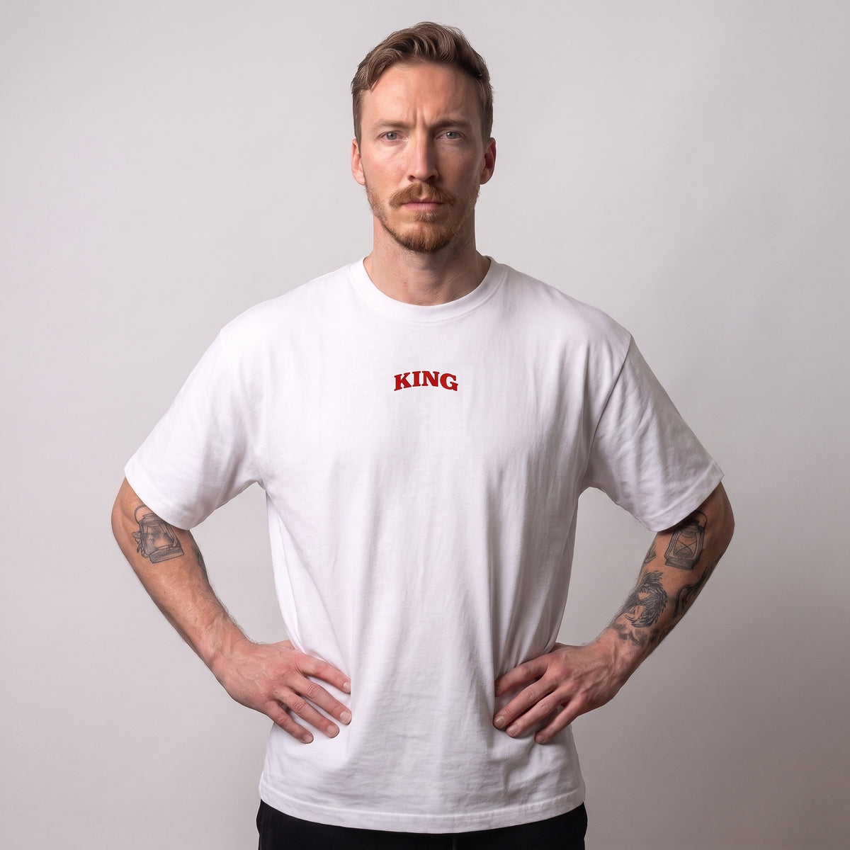 Male model wearing the white KING APEX King’s Bulk oversized T-shirt, front view showing the small red KING chest print.