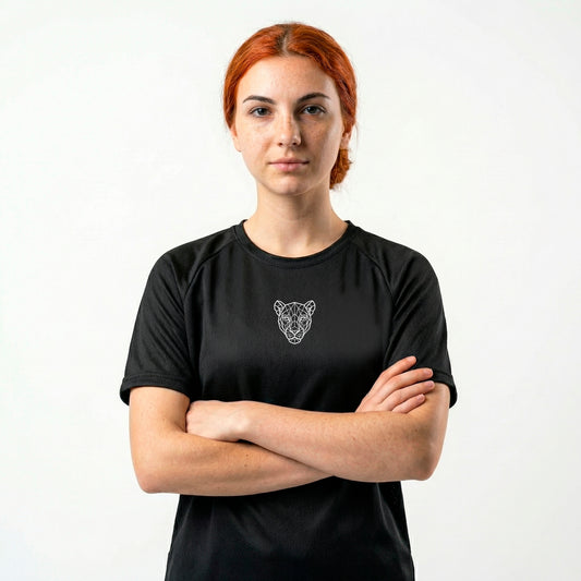 Woman wearing KING APEX black sports jersey with minimal lioness logo centered on chest