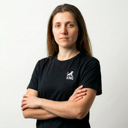 Female model wearing KING APEX black athletic sports tee with minimal lioness logo
