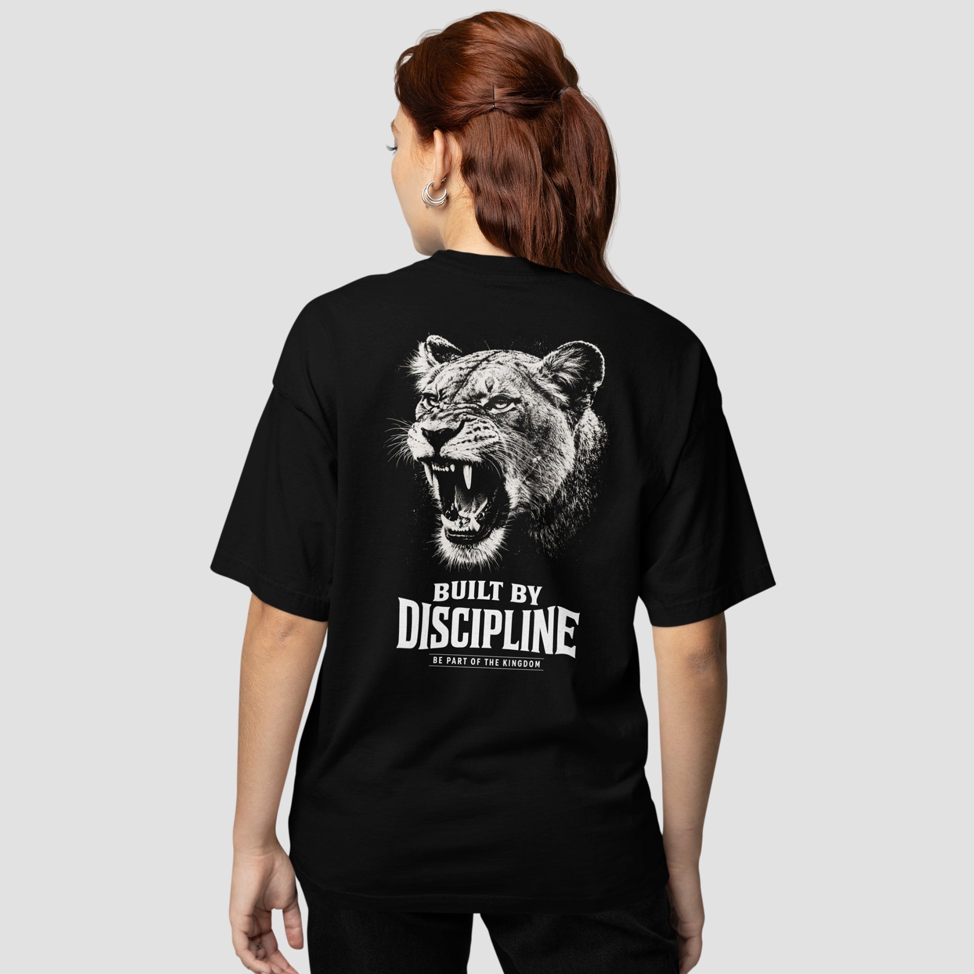 model wearing KING APEX lioness oversized black t-shirt with Built by Discipline lioness design
