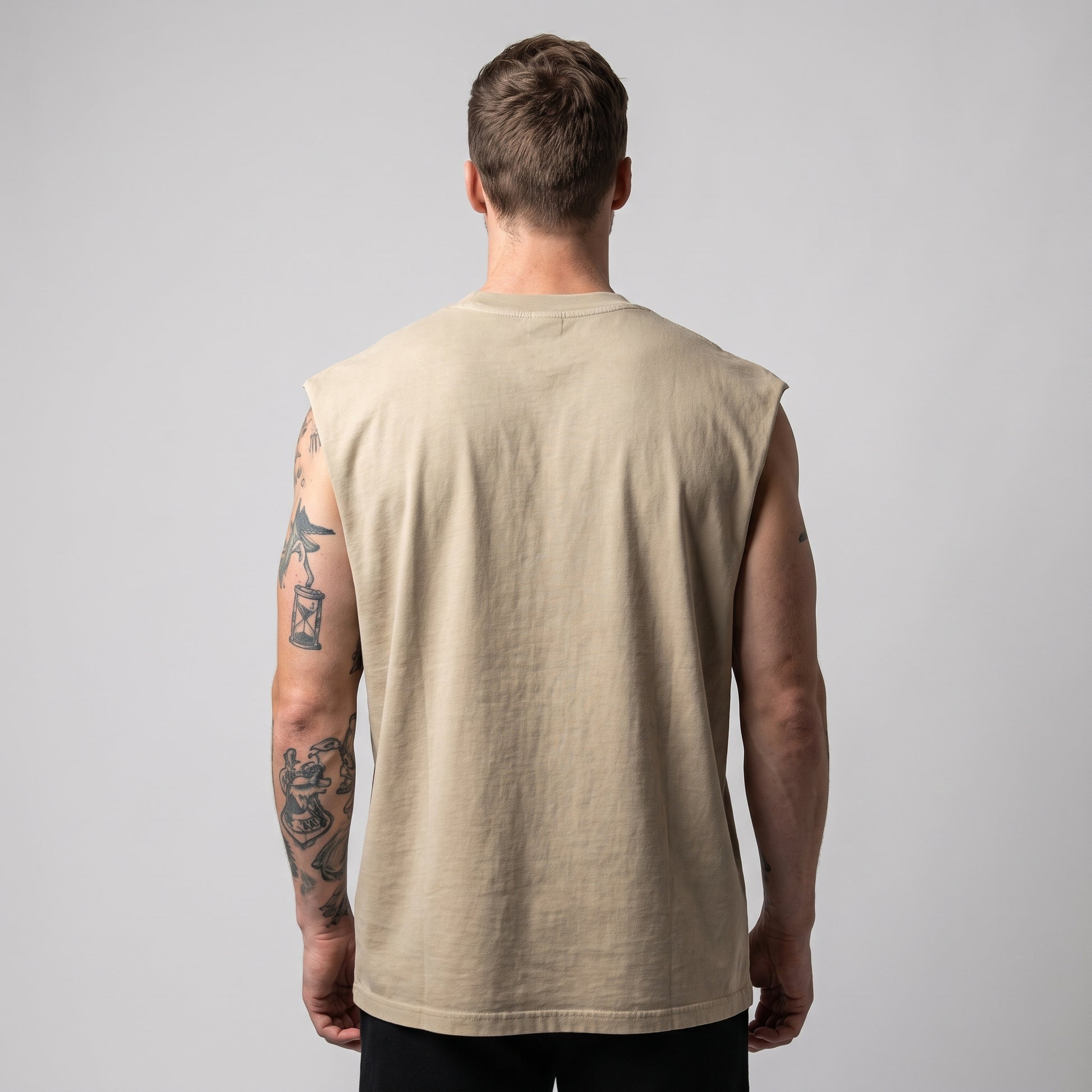 Back view of a male model wearing the KING APEX Men's Heavy Faded Tank in sand with a relaxed oversized and boxy construction.
