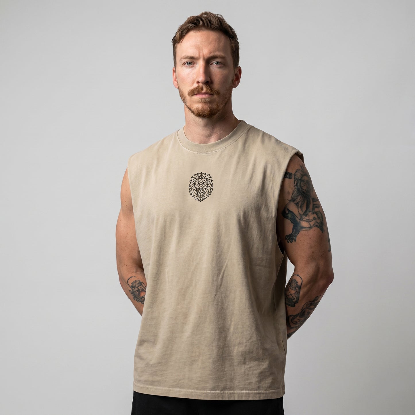 Male model wearing the KING APEX Men's Heavy Faded Tank in Sand Lion, front view with hands behind his back.