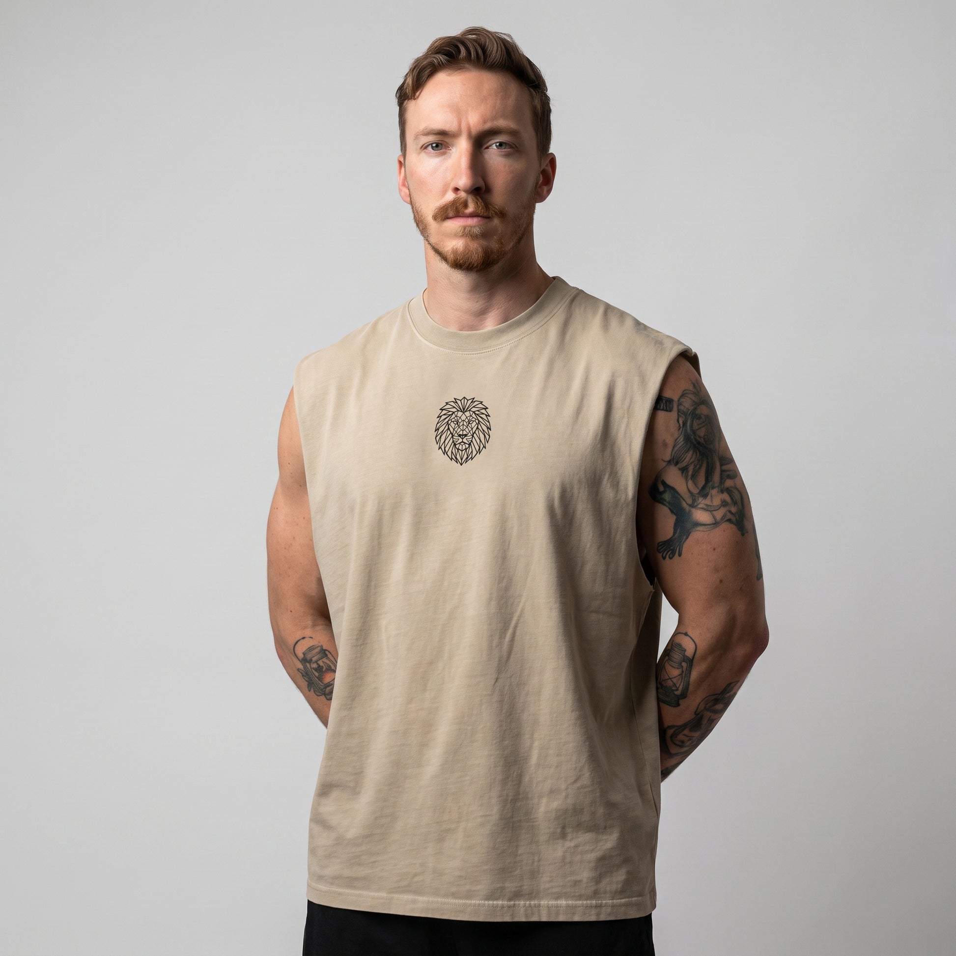 Male model wearing the KING APEX Men's Heavy Faded Tank in Sand Lion, front view with hands behind his back.