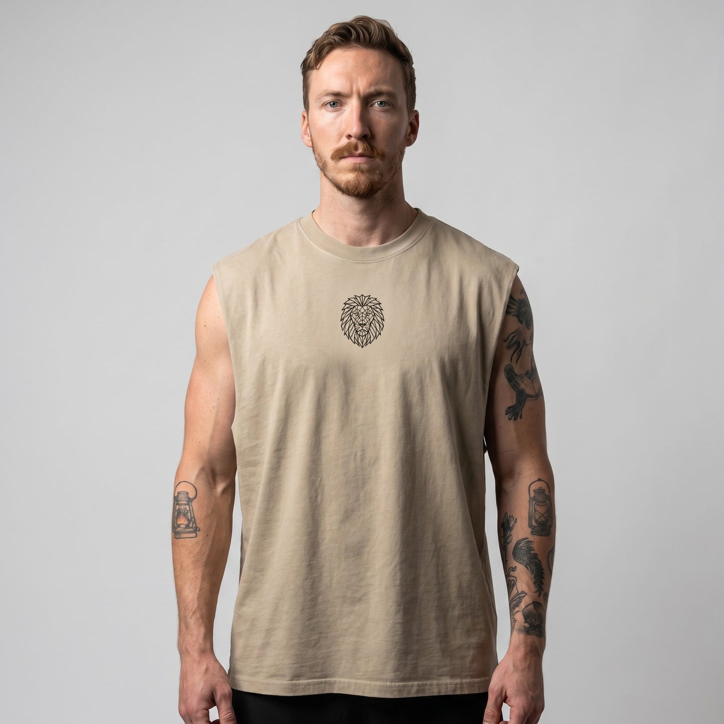Male model wearing the KING APEX Men's Heavy Faded Tank in sand, featuring a relaxed boxy fit and geometric lion chest logo.