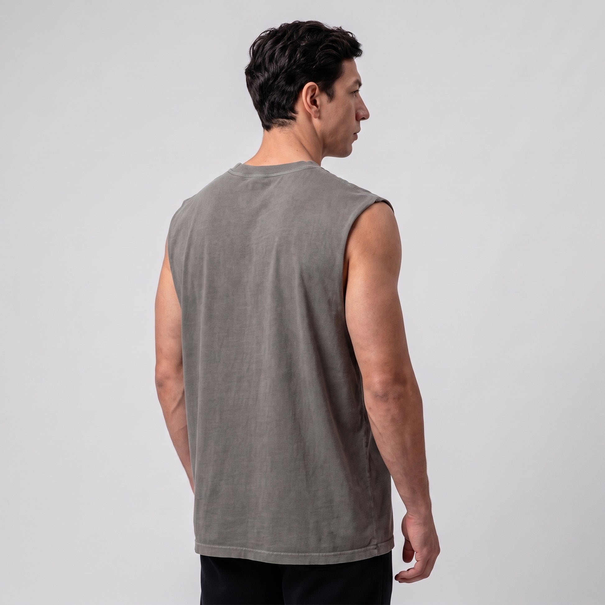 Male model wearing the KING APEX Men's Heavy Faded Tank in Stone Grey, three-quarter back view.
