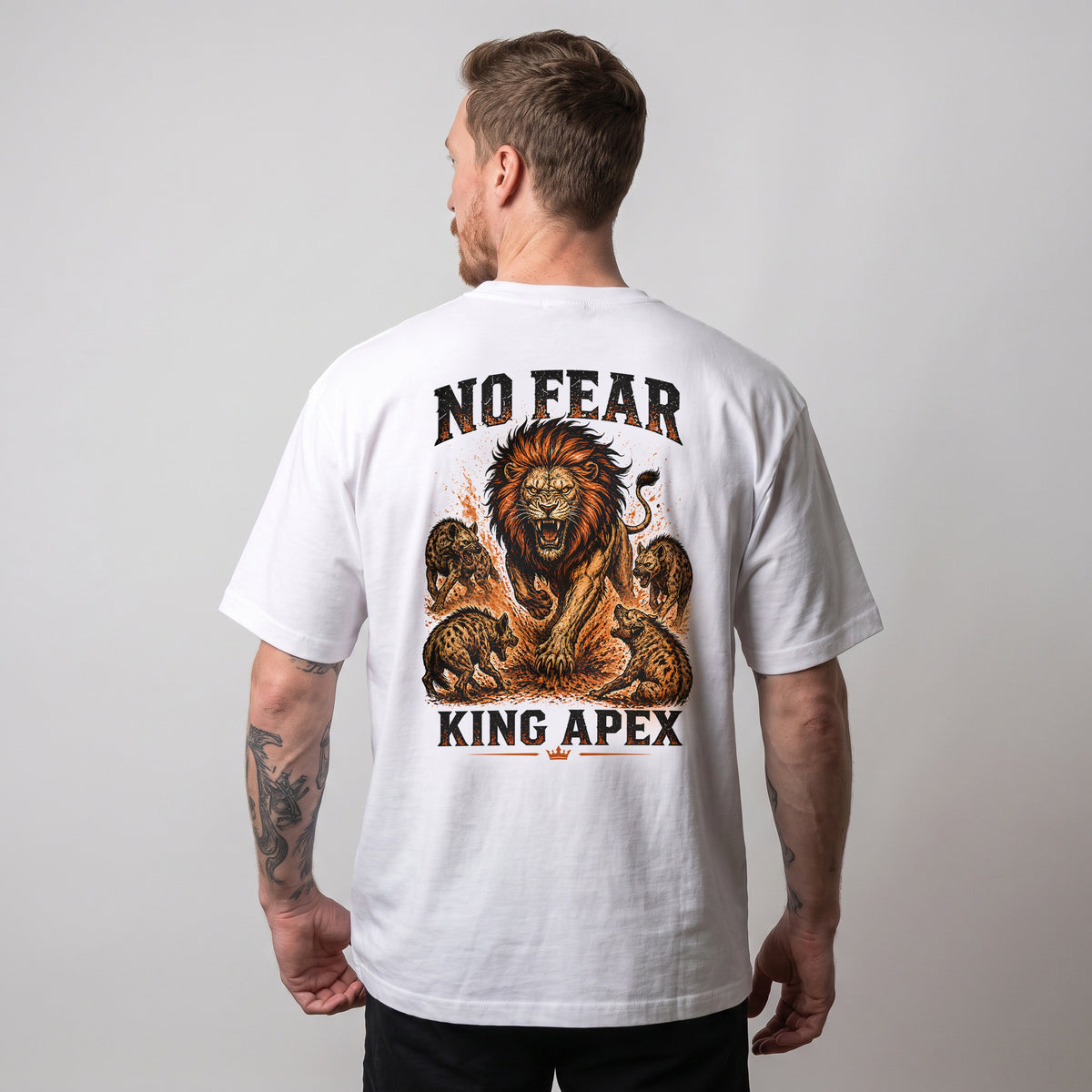 Modèle masculin portant le t-shirt oversize blanc KING APEX No Fear, avec le motif lion orange et noir visible au dos.