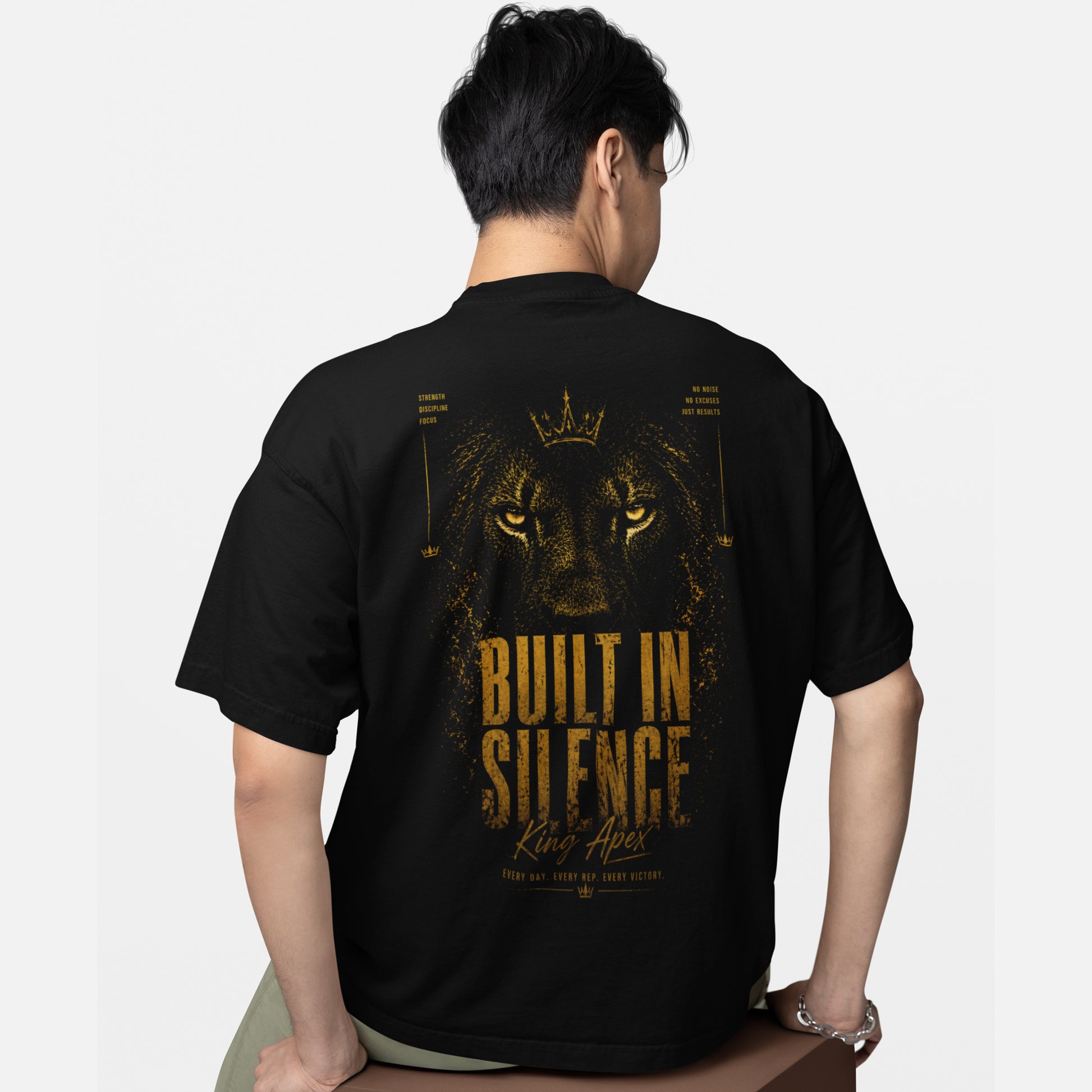 model wearing KING APEX oversized black t-shirt with Built in Silence golden lion design on back