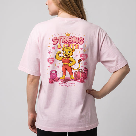 Woman wearing the KING APEX Soft Pink oversized T-shirt, showing the Strong & Cute lioness graphic on the back.