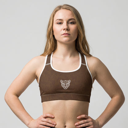 Woman wearing the KING Lioness Savannah Pattern Sports Bra Earth Edition in a confident power pose.