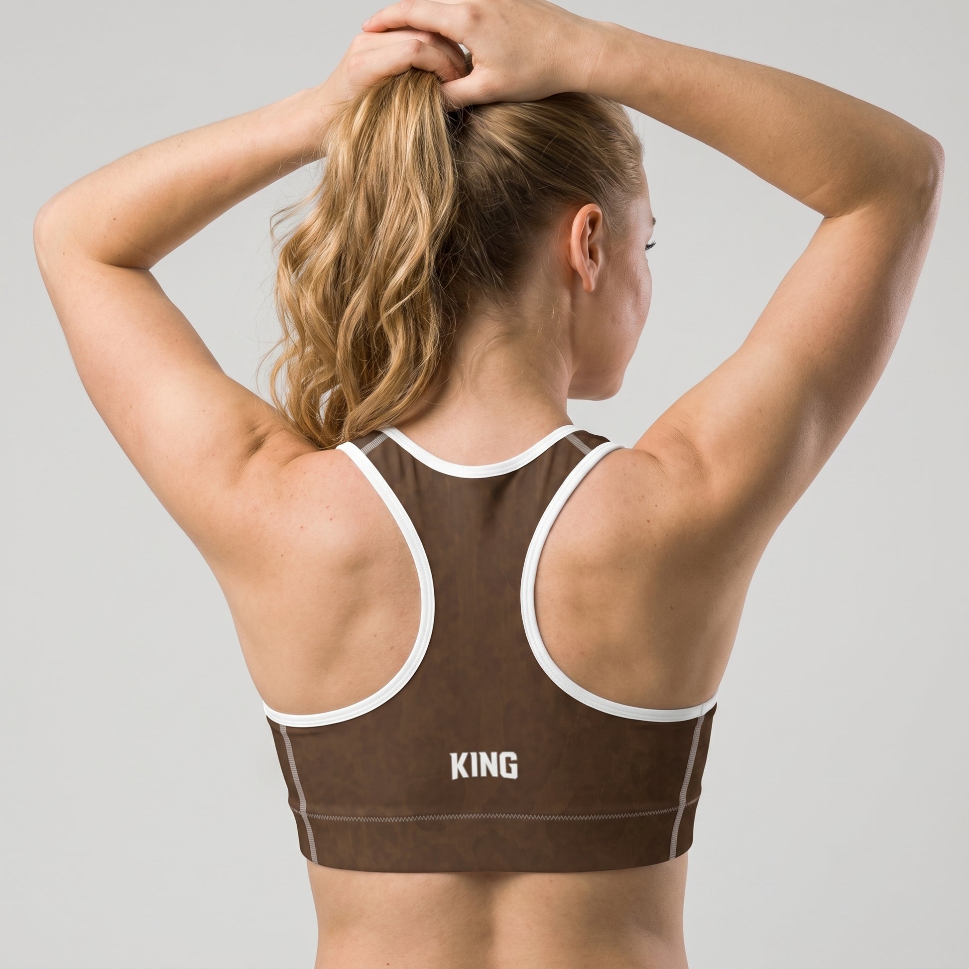 Woman wearing the KING Lioness Savannah Pattern Sports Bra looking over her shoulder.