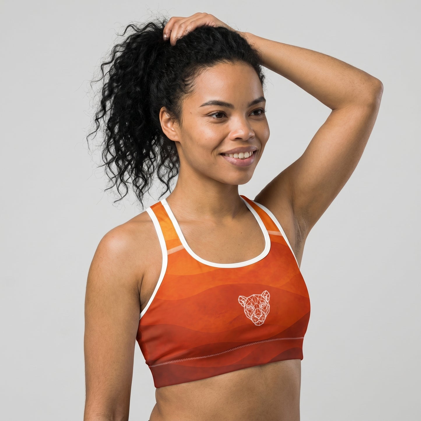 Front detail of KING Lioness Savannah Sports Bra Earth Edition featuring geometric lioness logo