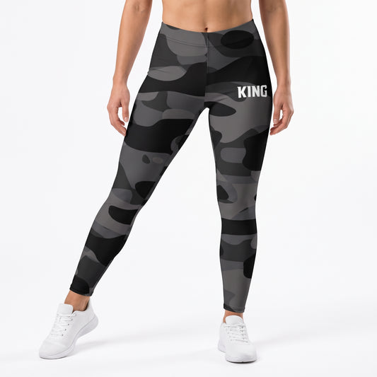 Front angled view of a model wearing KING APEX Lioness black and gray Shadow Camo high-waisted gym leggings.