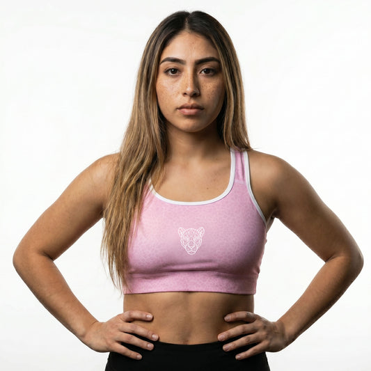 Model wearing KING Lioness sports bra in rose scale texture with geometric lioness logo front view