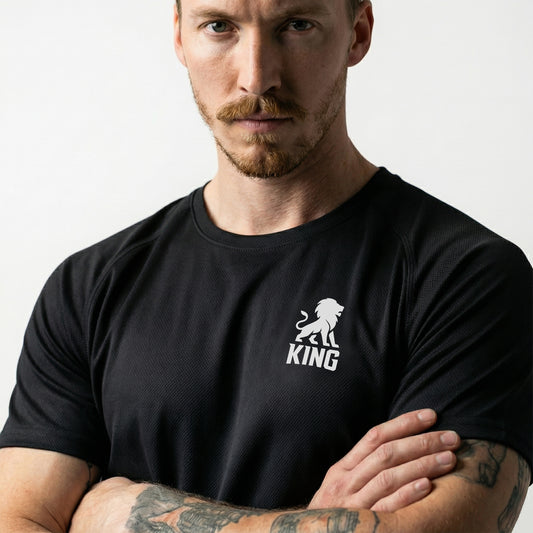 Male model wearing KING Sports Jersey Black with Minimal Lion Chest logo, close front view, premium athletic apparel