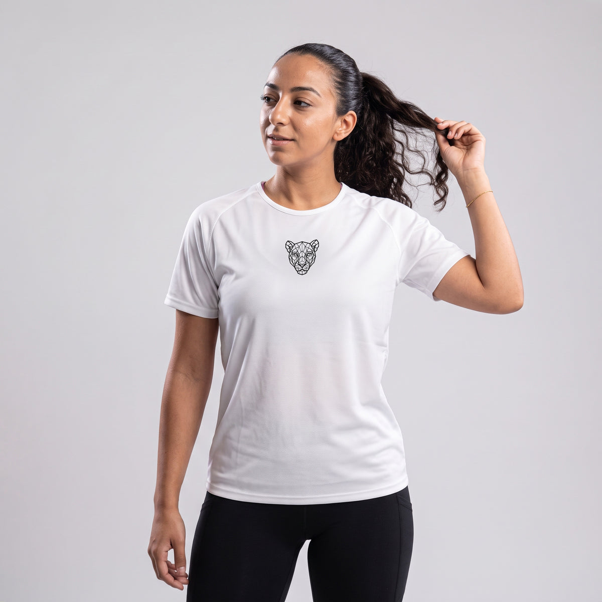 Woman adjusting hair, back view of white KING Sports Jersey with geometric lioness print