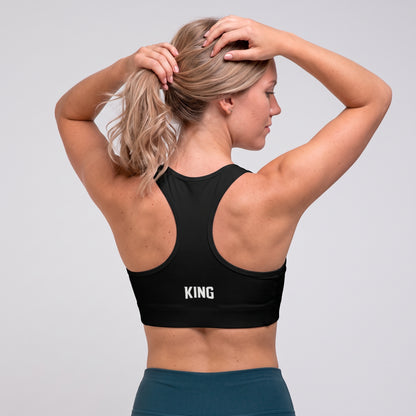 Angled back view of the KING Lioness Sports Bra in black on a female model.