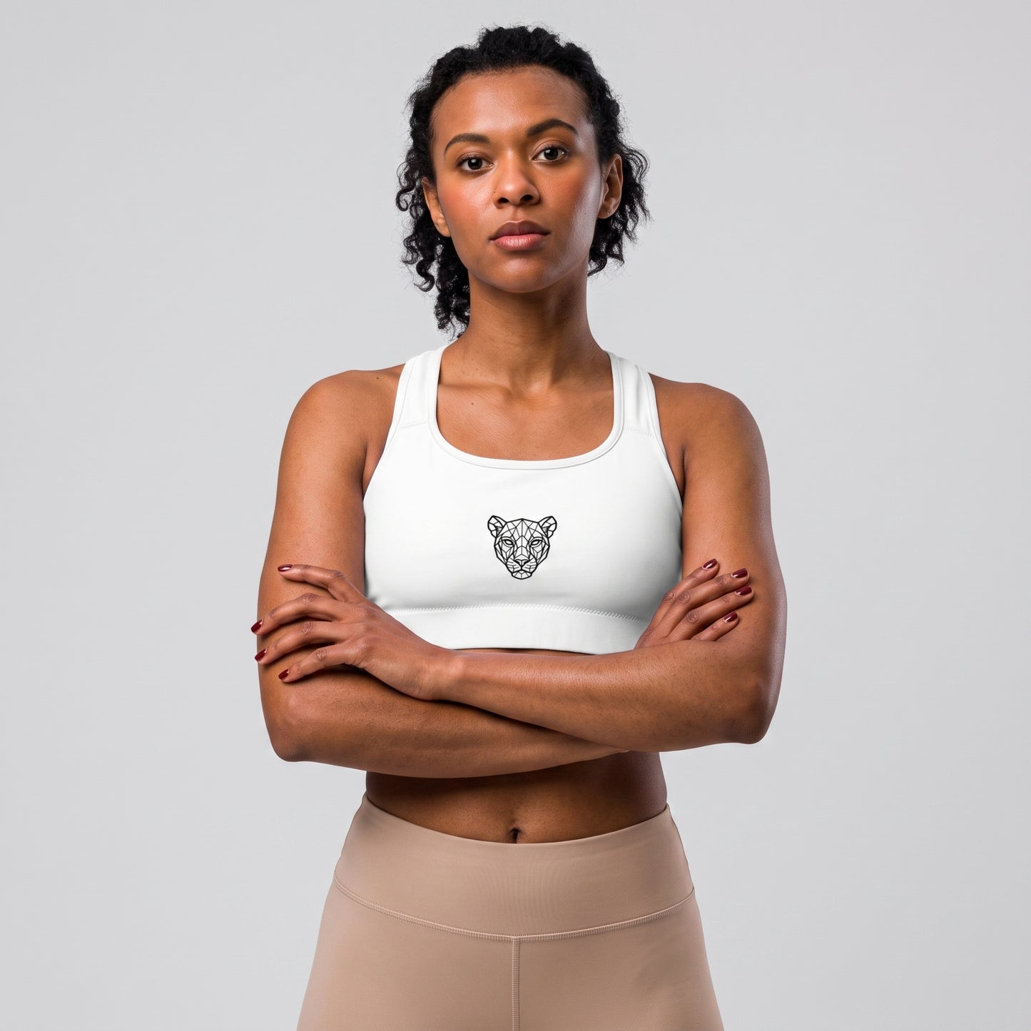 Woman wearing the KING Lioness Sports Bra in black with arms crossed, front view.