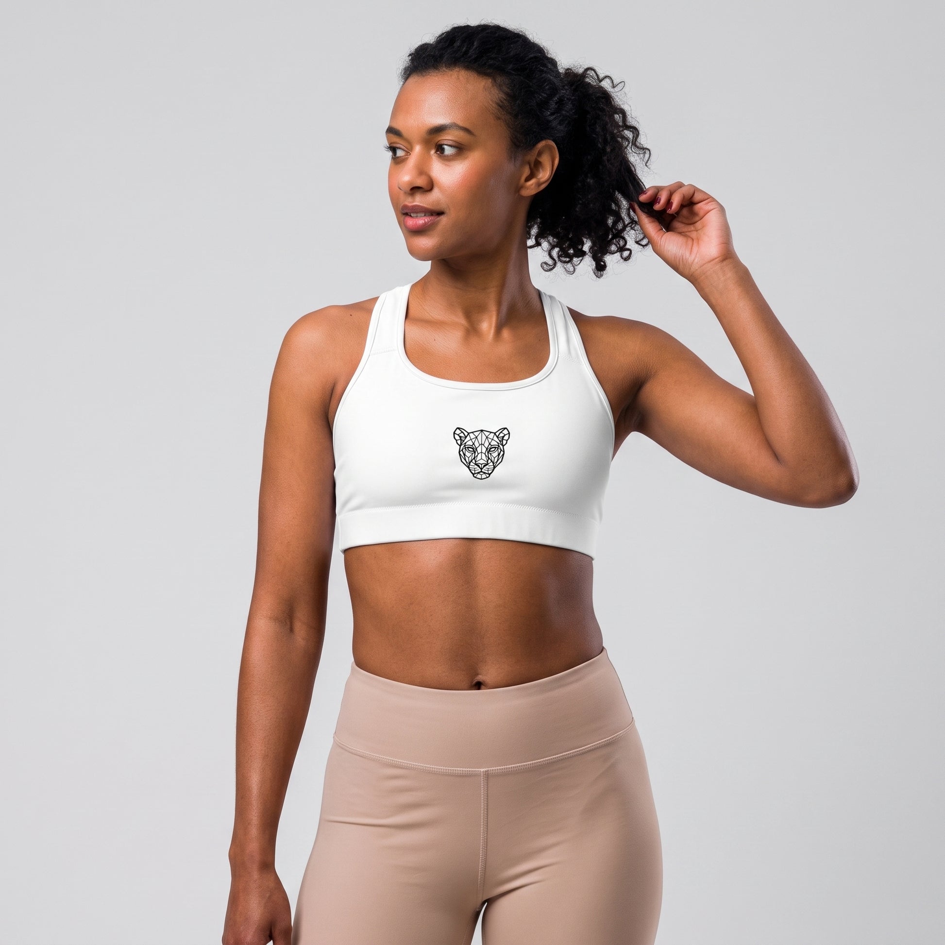 Three-quarter view of the KING Lioness Sports Bra in black on a female model.