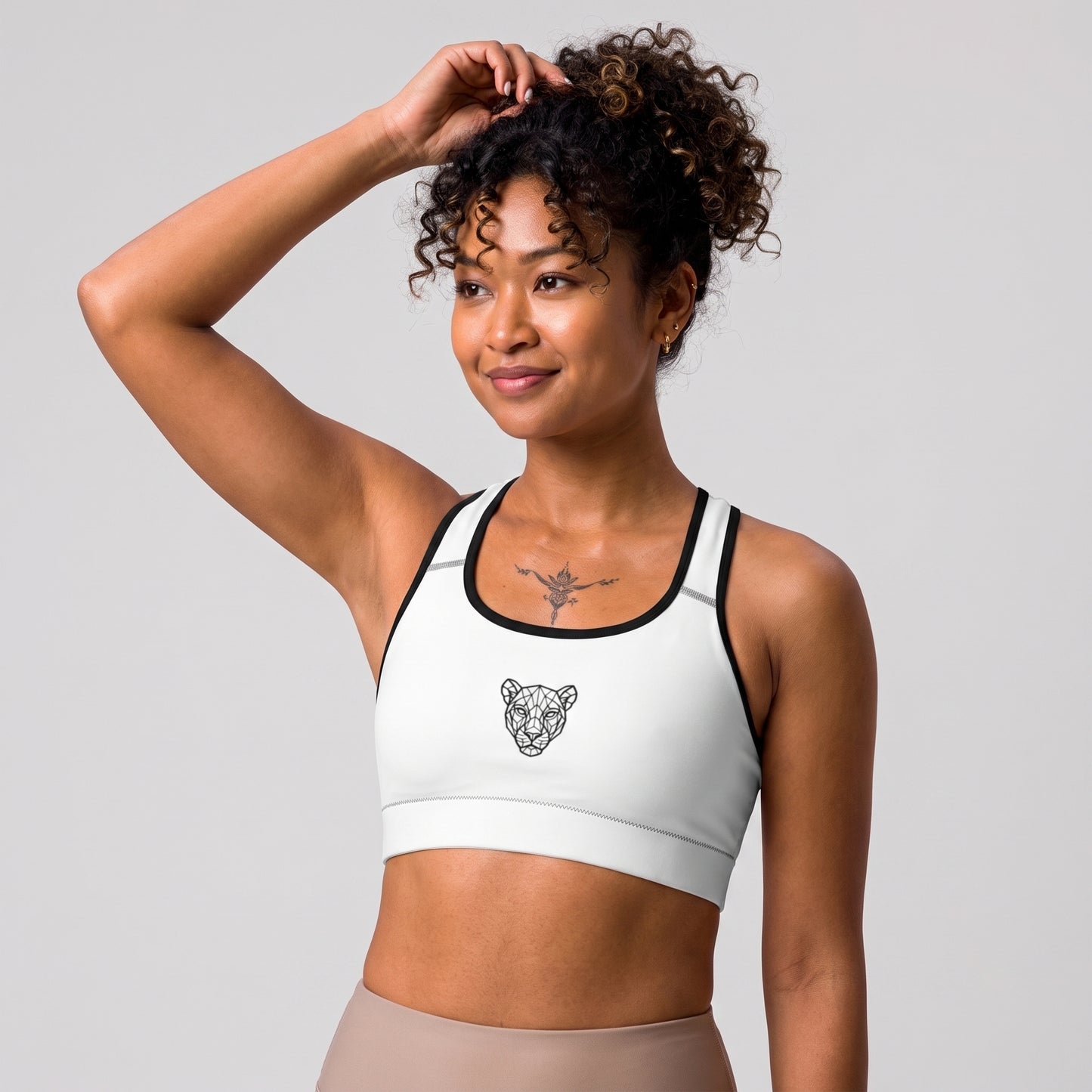 Side view of the KING Lioness Sports Bra in white with black piping on a female model.