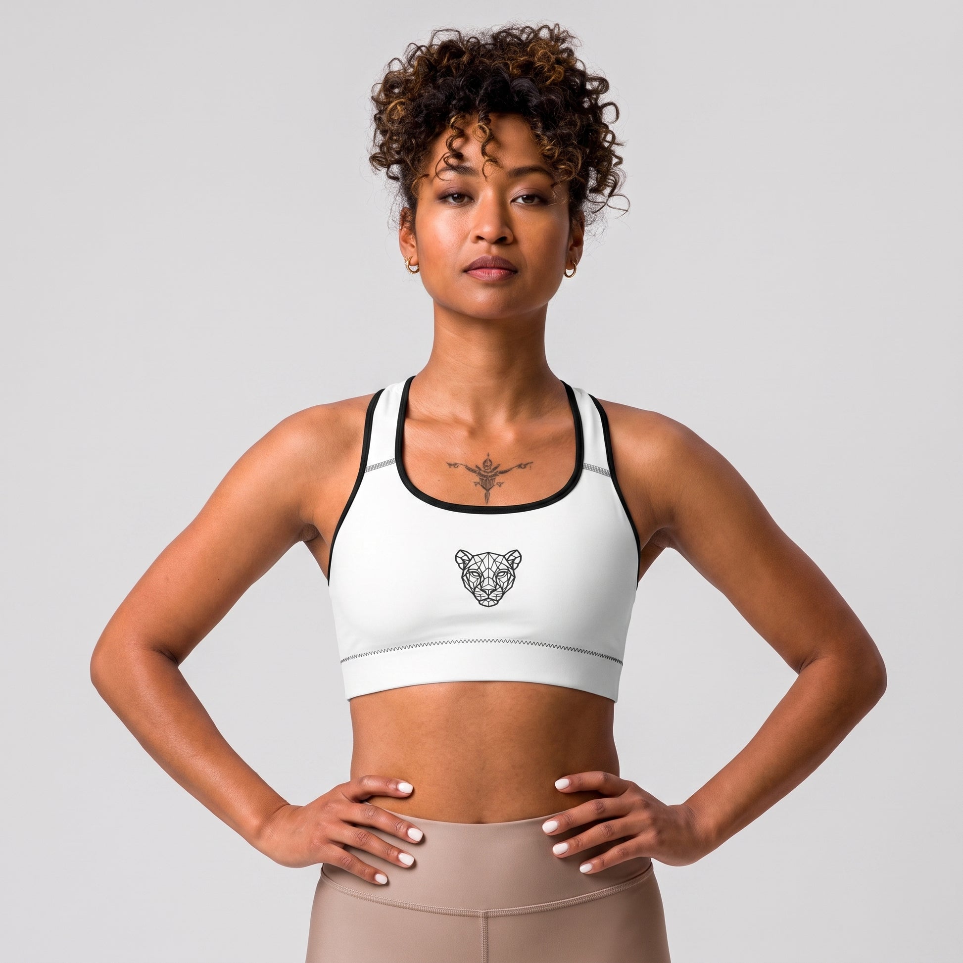 Female model wearing the KING Lioness Sports Bra in white with black piping.